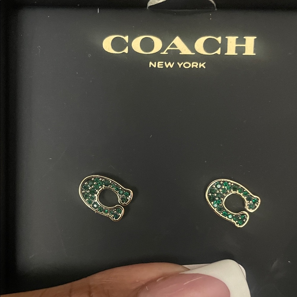 Gold with green stone coach C earrings .